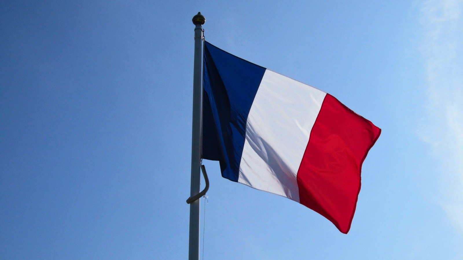 Drapeau français volant au vent lors d'une cérémonie de commémoration