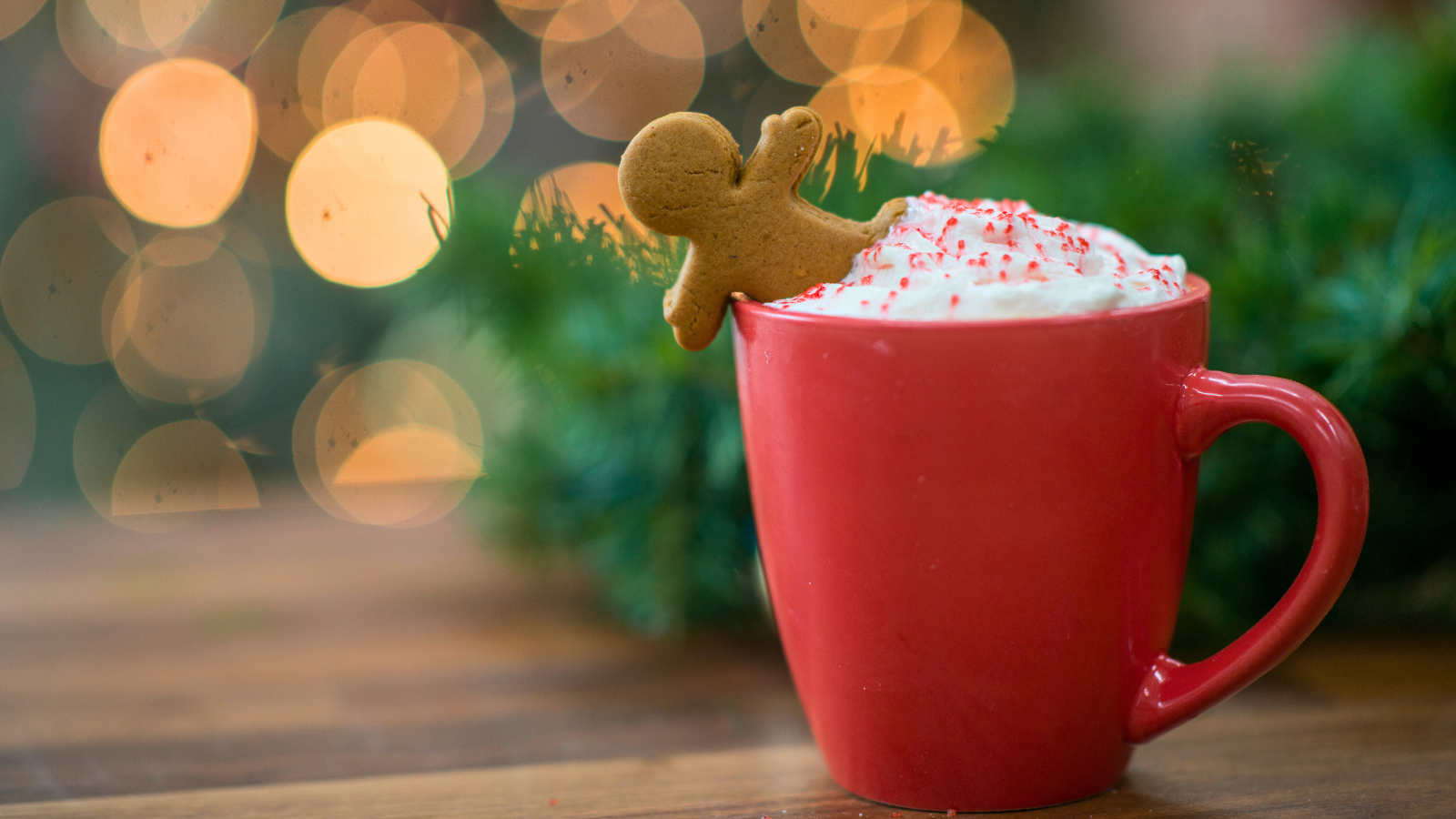 Tasse de chocolat chaud avec un biscuit en pain d’épices, dans une ambiance cosy et chaleureuse de Noël.
